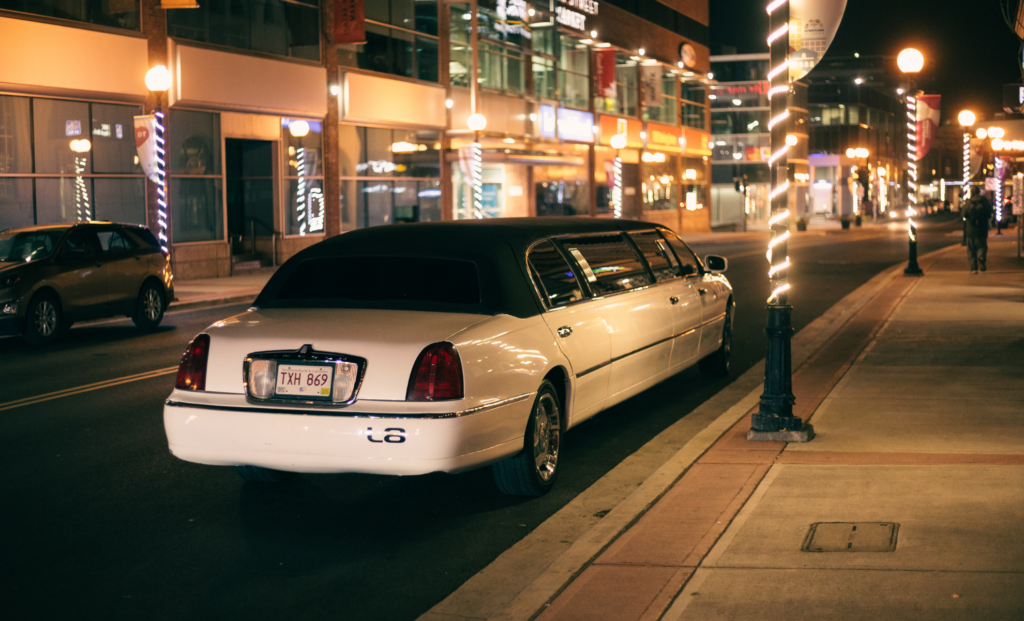 White stretch limousine parked on a city street at night