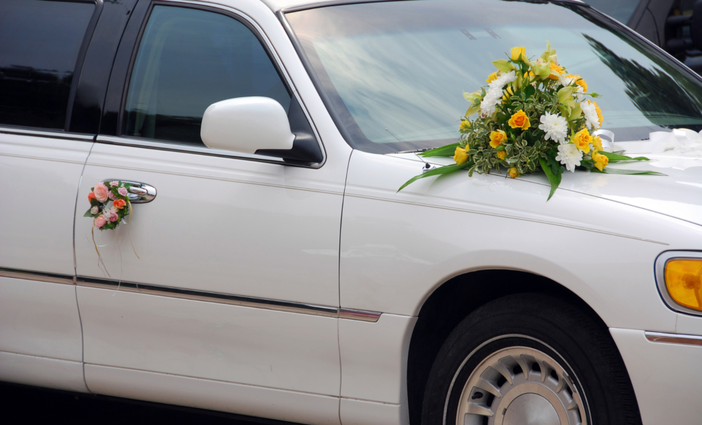 White stretch limousine decorated with a wedding flower bouquet